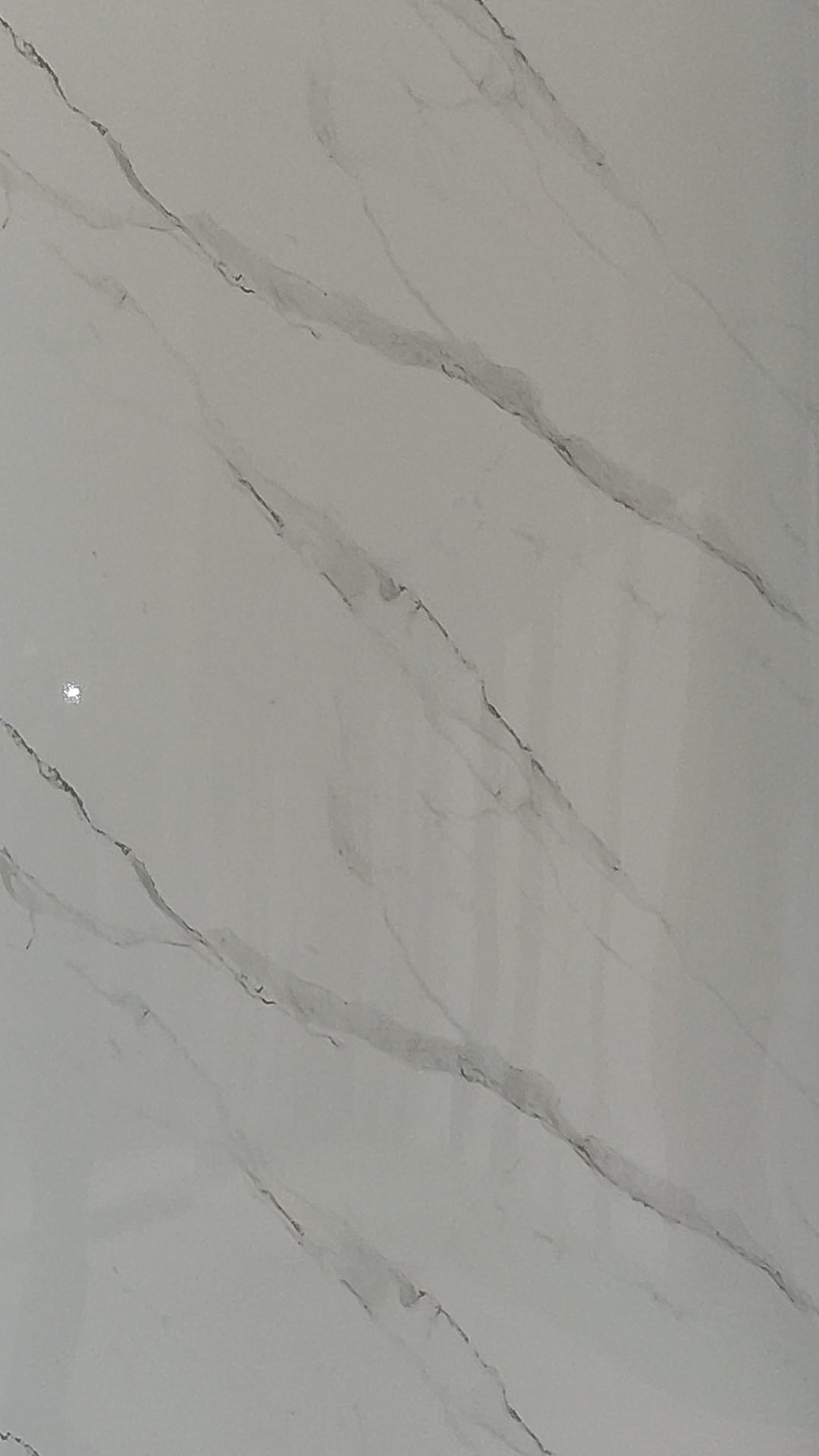 Luxury Bianco Serene gloss white wall panel with abundant grey veining in a modern Tenerife living room.