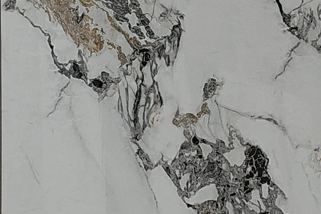 Close-up detail of the charcoal, black and warm bronze veins on the Imperial Statuario panel.